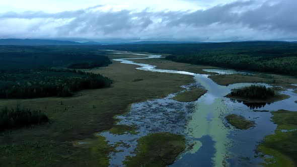 Aerial hyperlapse flying over a dark ominous landscape with the still waters of Shirley Bog winding