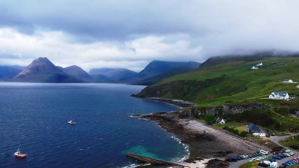 Panning drone shot of mountain harbour village by the ocean. Aerial video shot by a drone in Scotlan