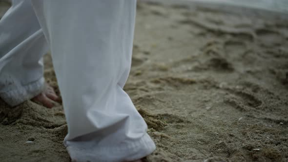 Man Feet Taking Steps on Sand Closeup