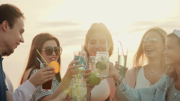 Friendly and Cheerful Company Having Fun on Outdoors, Drinking Together Summer Urban Cocktails