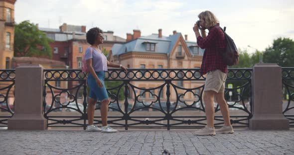 Boyfriend Tourist on Summer Trip Taking Pictures of Girlfriend Using Vintage Camera