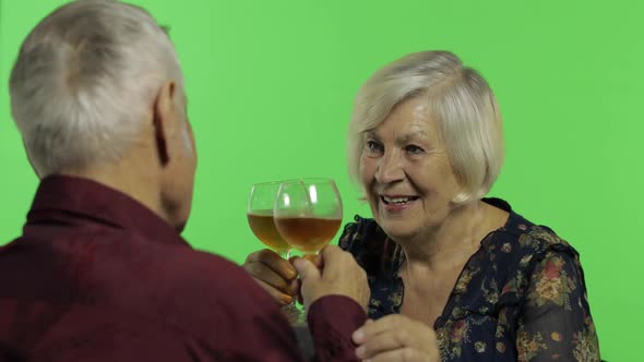 Senior Aged Woman Drinking Wine with a Elderly Man Companion on Chroma Key