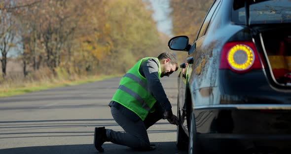 Man Changing Wheel on the Car at the Side of the Road