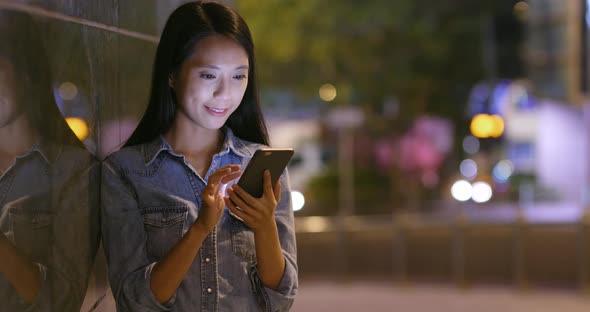 Woman Looking at Mobile Phone in City 