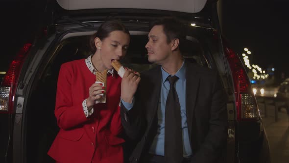 Business Colleagues Sharing Meal in Car at Night