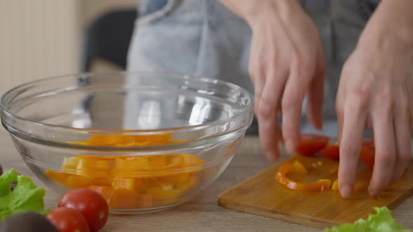 Female Hands Adding Organic Bell Pepper and Tomato in Transparent Salad Bowl