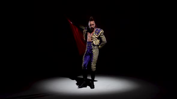 Torero in Blue and Gold Suit or Typical Spanish Bullfighter Isolated Spotlight on a Black Background