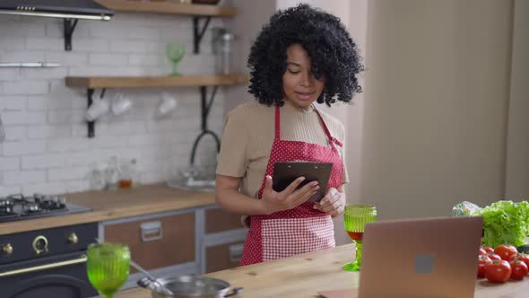 Charming Cheerful Young African American Woman Reading Recipe Out Loud Smiling