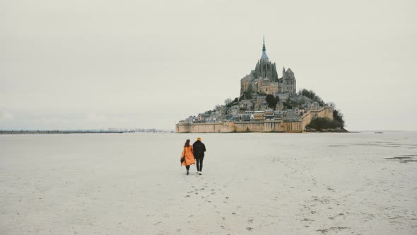 Beautiful Cinematic Shot, Drone Follows Young Happy Couple Walking Towards Mont Saint Michel