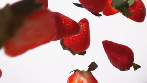 Closeup of the Red Ripe Strawberry Halves Flying on a White Background