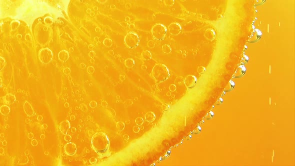 Air bubbles around an orange slice.