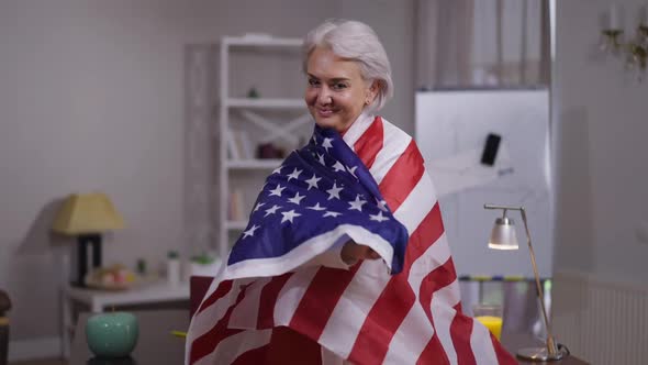 Proud Confident Happy Mature Woman Wrapping in USA Flag Looking at Camera Smiling