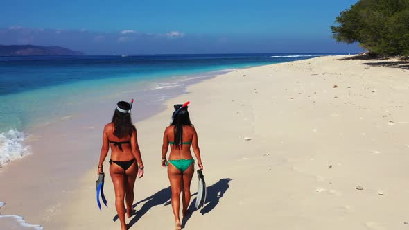 Girls sunbathing on luxury shore beach time by turquoise ocean with white sandy background of Indone