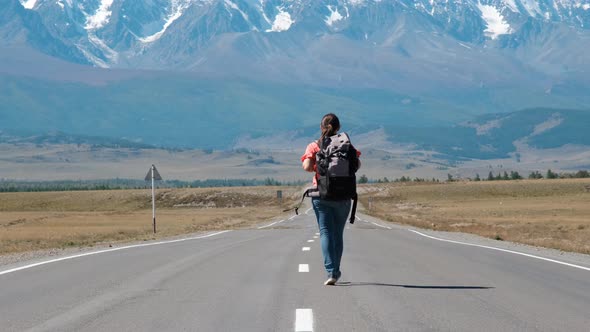 Woman with Backpack Traveling Alone in Mountains