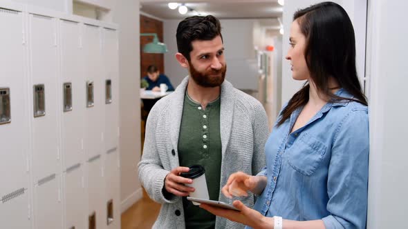 Business executives discussing over digital tablet in locker room