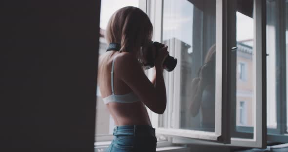 A girl taking picture with a professional camera in the livingroom