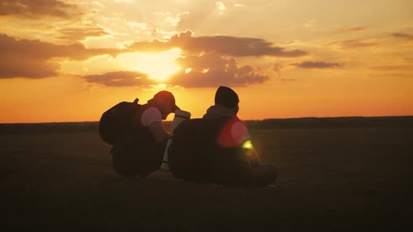 The Silhouette of Two Man on the Top of Mountain with Backpacks and Other Gear Expressing Energy