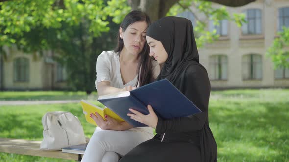 Side View of Confident Young Students Studying Outdoors on Sunny Day. Portrait of Positive Muslim