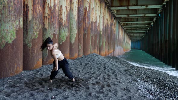 Modern Dance Performance and Rehearsal on Sea Shore Young Sexy Woman is Dancing Under Pier