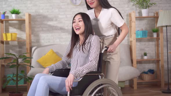 Portrait of an Asian Disabled Woman in a Wheelchair with Her Friend