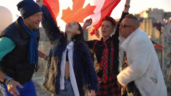 Group of Asian and Caucasian Adult Friends with Canadian Flag Posing on Roof in Urban City at Sunset