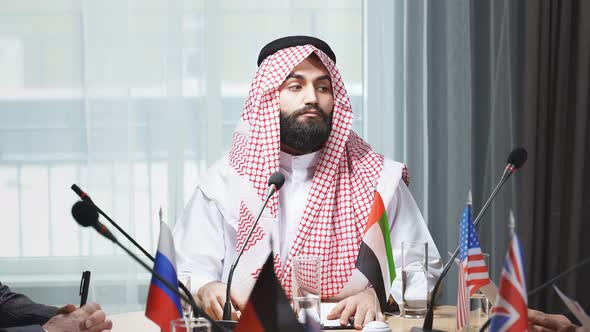 Portrait of Serious Young Arabic Man Wearing Traditional Emirates Clothes on Meeting