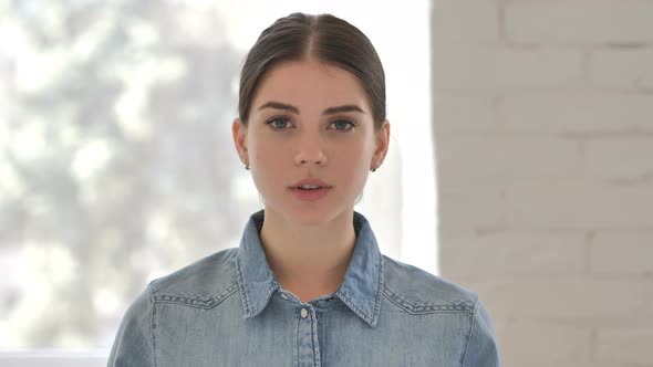 Portrait of Serious Young Girl Looking at Camera