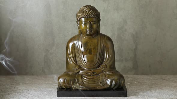  Smoke of incense in front of a traditional Asian buddha