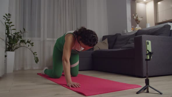 Sporty Adult Woman Holding Distant Workout Using Smartphone at Home