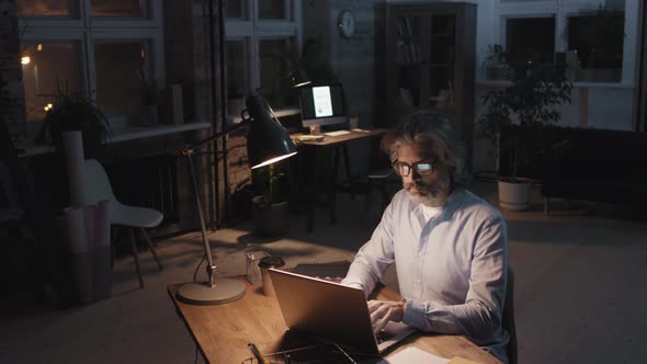 Man Working In Dark Empty Office Alone