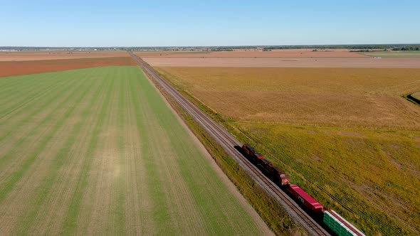 Transportation industry: freight train traveling on countryside, 4K UHD drone aerial footage.