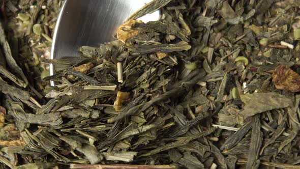 Green tea with hemp and rosebush close-up. Dried leaves of medicinal herbs with marijuana in a spoon