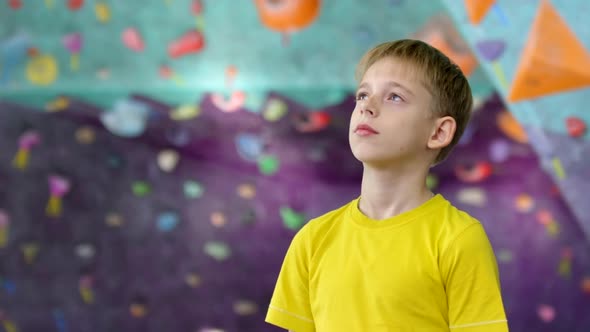 Caucasian Teenage Climber Looking at Climbing Wall