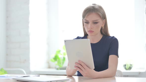 Woman Reacting to Loss on Tablet in Office