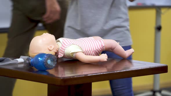 First aid training. Woman shows how to do CPR on a doll dummy