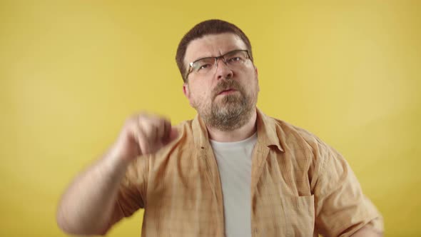 Caucasian middle-aged man in glasses with a beard dances to the music