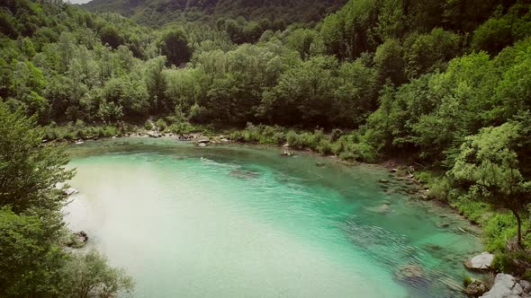 Aerial view of the Soca river surrounded by nature at summer time in Slovenia.