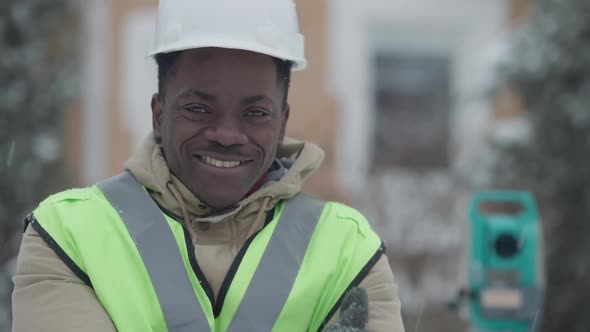 Closeup of Confident Handsome Positive African American Man in Hard Hat Smiling Looking at Camera