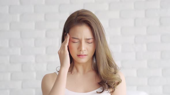 Asian young Woman has a Migraine and headache after wake up in the morning,Healthcare Concept