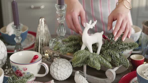 Christmas Table Decoration. Festive Table Setting. Female Hands Decorate the Table for Christmas