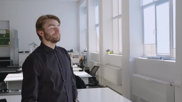 Bearded Man Stands and Look on the Window