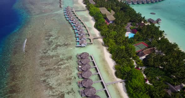 Wide overhead tourism shot of a paradise sunny white sand beach and aqua blue water background