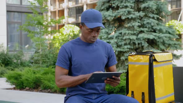 Camera Zoom in Afroamerican Man Courier Delivery Uses Tablet Looking Camera