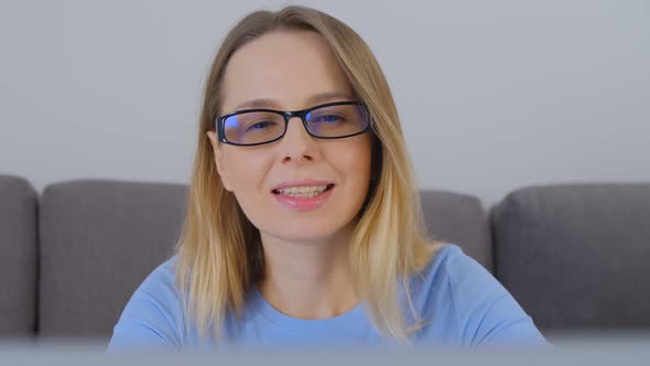 Happy woman doing distant work online on notebook computer with cheerful smile in 4k video