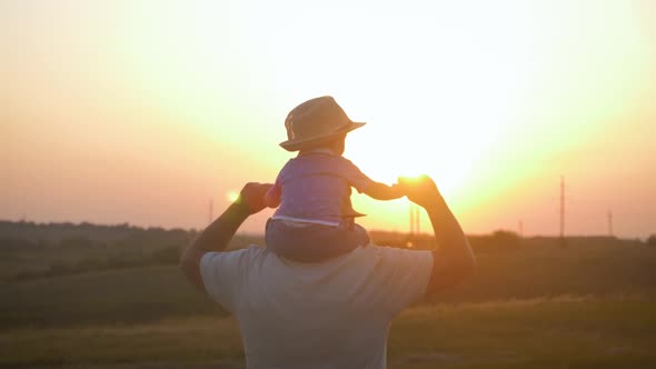 Two Generations Silhouette of a Mature Grandfather and Little Grandson Play at Sunset.