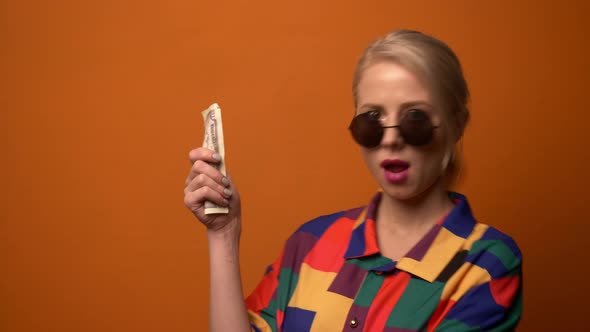 Style blonde in 90s shirt with money on orange background