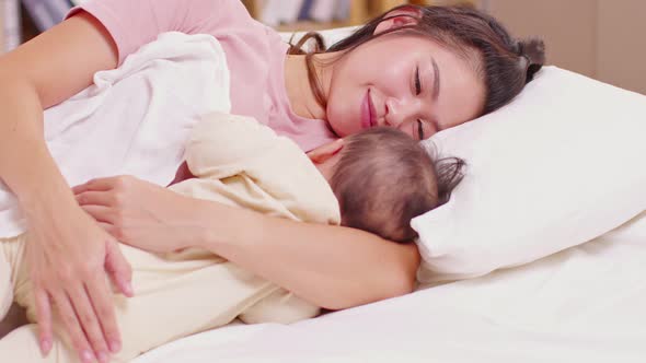 Adorable sleeping newborn baby relax in mother arm safety and comfortable on bed