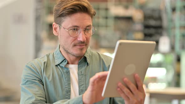 Portrait of Attractive Middle Aged Man Using Digital Tablet