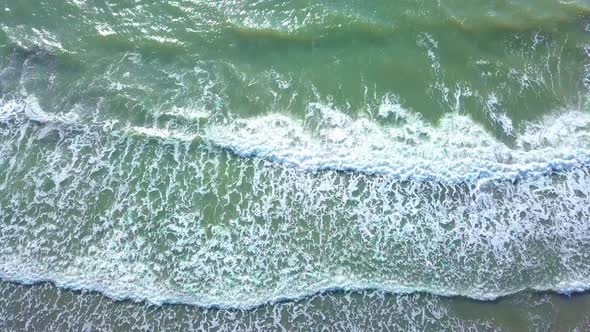 Drone view of the beautiful waves on the sandy beach,