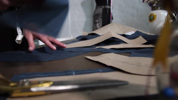 Seamstress's Hands Laying Out Patterns on Table